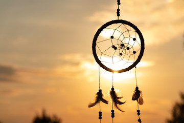 It's a native American dream catcher and golden rays of the sunset. Beautiful calming scenery. Infuse positive thoughts, like a pleasant wind melody - Powered by Adobe