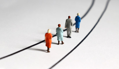The back of the miniature people walking down the narrow road. - obrazy, fototapety, plakaty