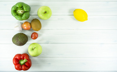 Fruit Salad with kiwi, tomatoes, apple, avocado, Red chilli, Green pepper, garlic, lime, vitamin snack on white wooden background top view,Food and health.
