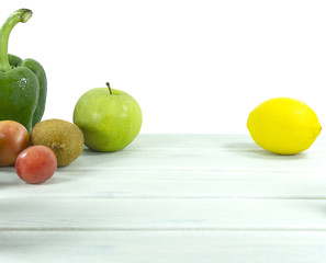 Fruit Salad with kiwi, tomatoes, green apple, Green pepper, lemons, vitamin snack on white wooden background Front view,Food and health, Clipping path.