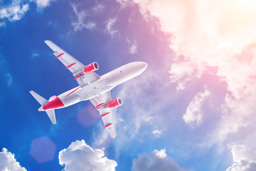 Airplane flying in the cloudy sky, bottom view