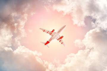 Fototapeta na wymiar Airplane flying in the cloudy sky, bottom view