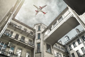 Airplane flying over old building with balconies