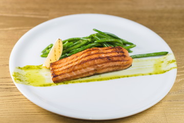Grilled salmon with asparagus on a white plate