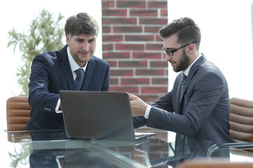 Two businessmen working on a laptop in the office