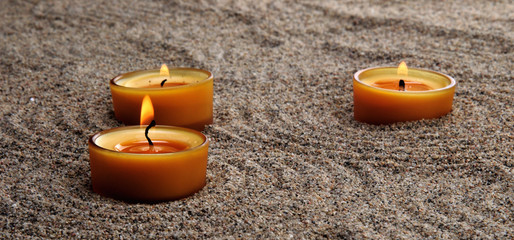 Zen composition. Candles in the sand. Calming patterns on the sand.