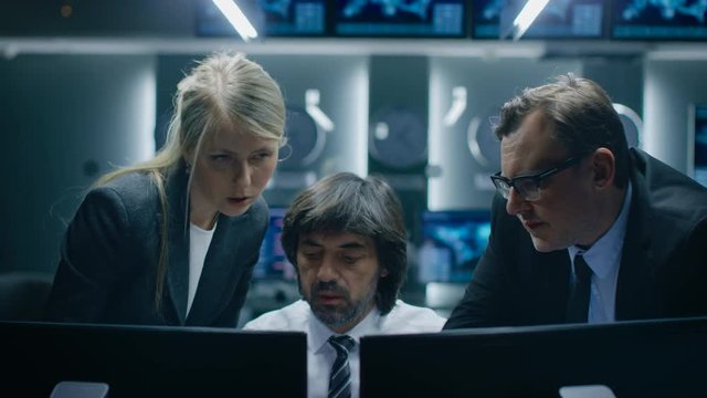 Male and Female Operators Working On Computers in System Control Room. Secret Government Agency Analysts Doing Research, Conducting Cyber Security Investigation.