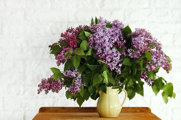 Lilac flower in a vase on a wooden background