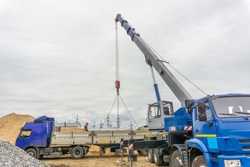 Unloading of building materials by crane at the construction site