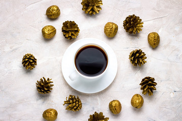 Cup of black coffee and Gold Cones on a light background. Winte