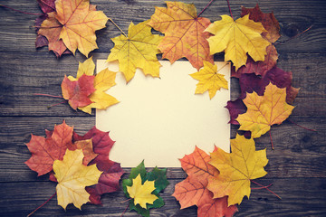 Frame of autumn leaves on wooden background