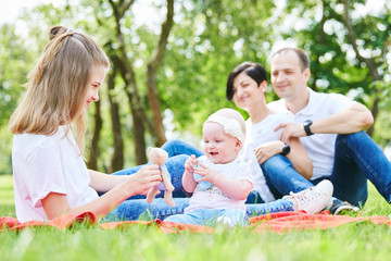 Naklejka na ściany i meble family with children in summer park. happy parenting