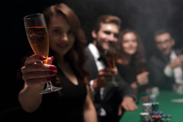 fashion woman with glasses of wine,sitting at a table in a casino