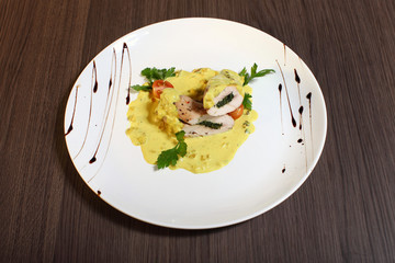 Stuffed cream cheese chicken roll with sauce on a plate. Chicken breasts filled and rolled up with a cream cheese and baked in the oven.