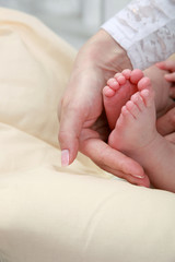 baby foot in mother's hands with care