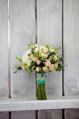 close up of wedding bouquet by wooden fence