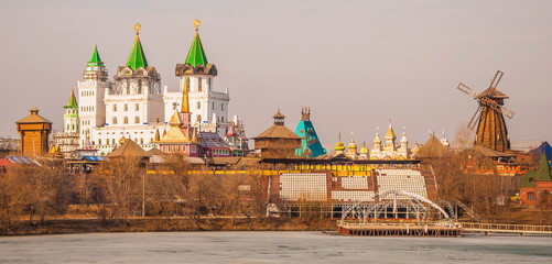 fabulous city with towers and a mill on the shore of a frozen pond