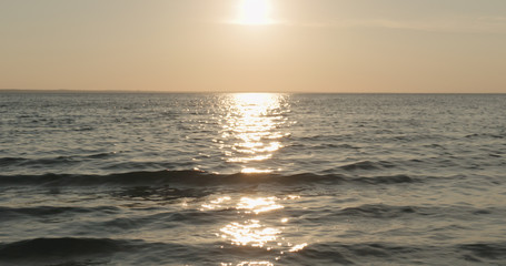 waves on a beach on a windy sunny day at sunset