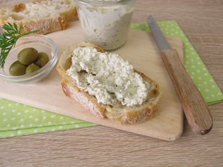 Aufstrich aus grünen Oliven und Frischkäse auf Weißbrot