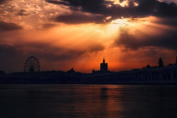 Sun beams trough the clouds in a cloudy sunset