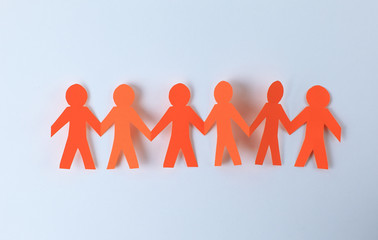 four paper men taking each other's hands