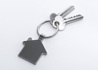 Key and keychain in the shape of a house isolated on white background.