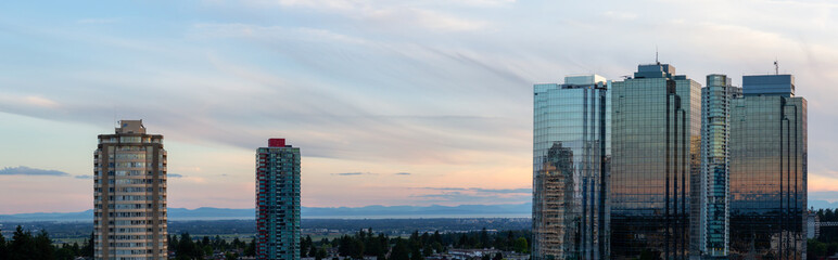 Aerial view of commercial and residential buildings during a vibrant summer sunset. Located near Metrotown Mall, Burnaby, Vancouver, BC, Canada.