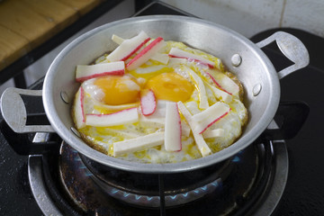 Two fried eggs with bacon for breakfast on gas stove,Close up.