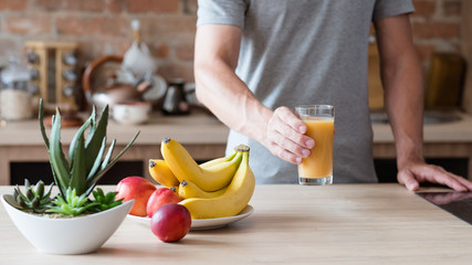 healthy eating habit. unrecognizable man holding a glass of freshly squeezed fruit juice. natural...