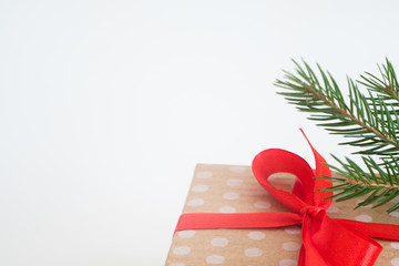 new year present in gift box wrapped in craft dotted paper and tied with a red ribbon bow. package...