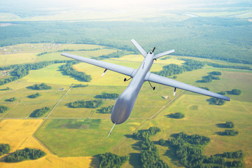 Patrolling unmanned aircraft in the sky above the terrain, fly tracking. - obrazy, fototapety, plakaty