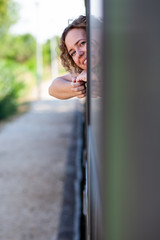 Obraz na płótnie Canvas Smiling happy woman looks out from a train window