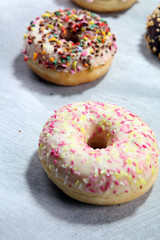 assorted donuts with chocolate frosted, pink glazed and sprinkles donuts