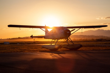 Obraz na płótnie Canvas Seaplane parked at the airport during a vibrant summer sunset. Taken in Pitt Meadows, Greater Vancouver, BC, Canada.