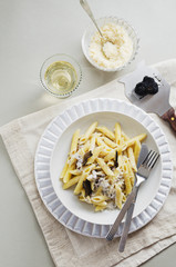 Penne alla norcina - Italian  pasta with  cream sauce and black truffle in white plate, free text space.