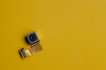 smartphone camera lens part on yellow background