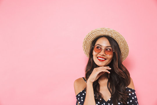 Smiling mystery brunette woman in straw hat and sunglasses