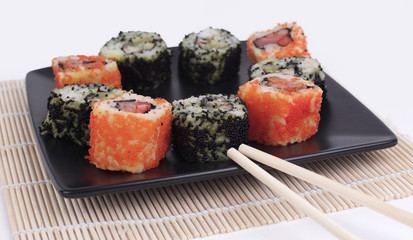 Sushi Set - different types of Maki sushi and chopsticks on a b