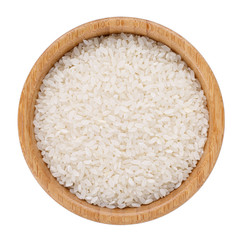 Arborio short-grain rice in wooden bowl isolated on white. Top view.