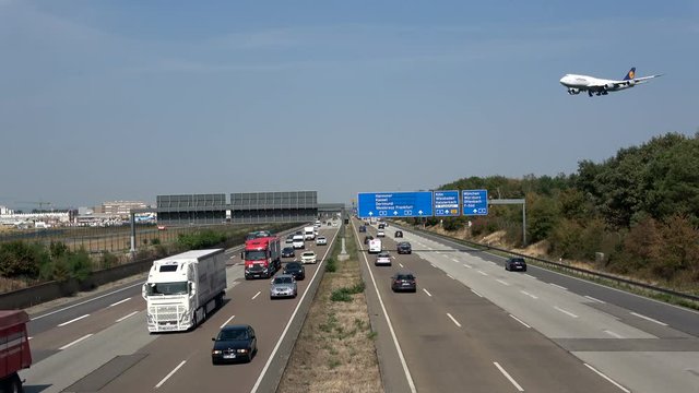 Flugzeug &uuml;berfliegt die Autobahn am Flughafen Frankfurt