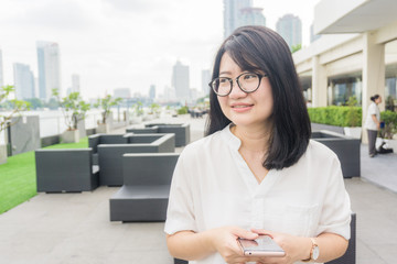 Business asian women use smartphone at park of building