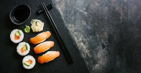 Selbstklebende Fototapeten Sushi serviert auf Teller auf dunklem Tisch © nerudol