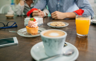Breakfast in a pastry shop with couple holding hands in background