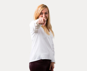 Middle age blonde woman with white shirt points finger at you with a confident expression on isolated grey background