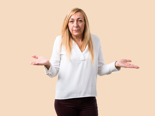 Middle age blonde woman with white shirt unhappy and frustrated with something because not...