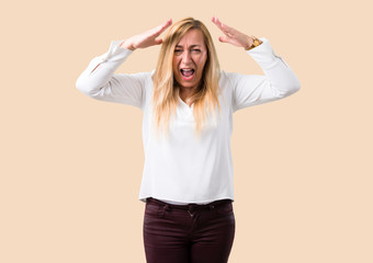 Middle age blonde woman with white shirt with surprise and shocked facial expression. Gaping...