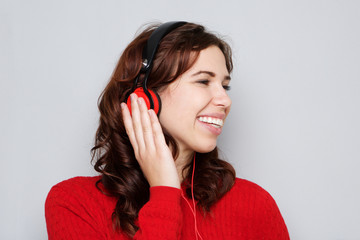 Close up happy young woman listening to music with headphones