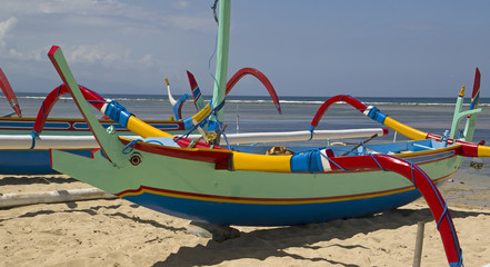 Colored fishing boats lie on the white beach of Sanur on Bali indonesia