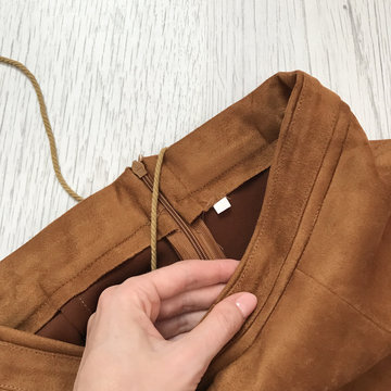 Details Of A Brown Suede Skirt On A Wooden Background