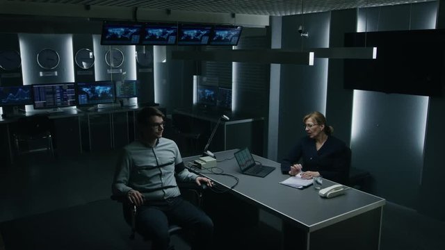 Female Special Agent Conducts Lie Detector Test on a Young Suspect. Corporate Spy Undergoes Polygraph Test, Expert Examiner Questions Accused in Interrogation Room. Computer Records Reactions.